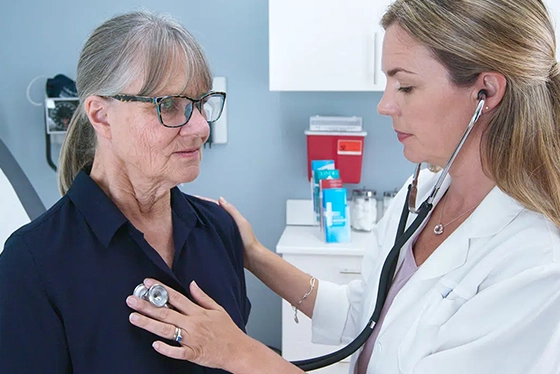 Doctor Performs Checkup on Elderly Woman in Primary Care Clinic