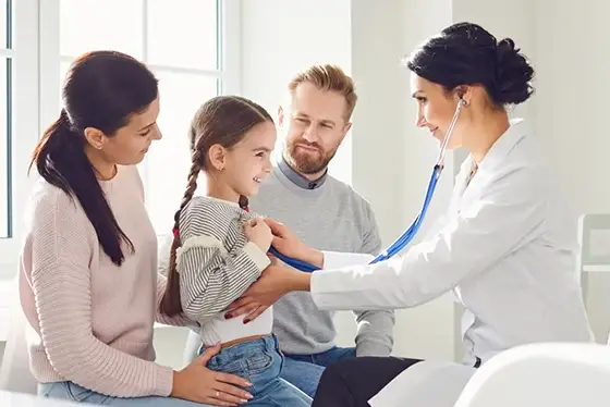 Doctor Performing Check-Up on Child with Parents at Family Medicine Clinic